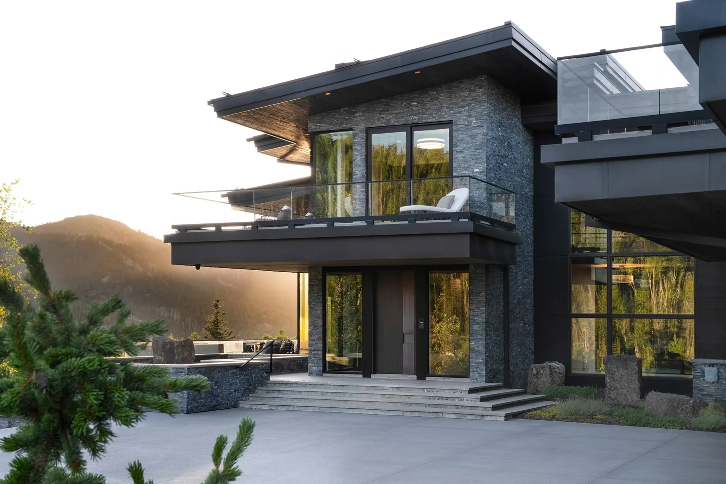 Entry court with cantilevered roof plane and mountain ridgeline beyond