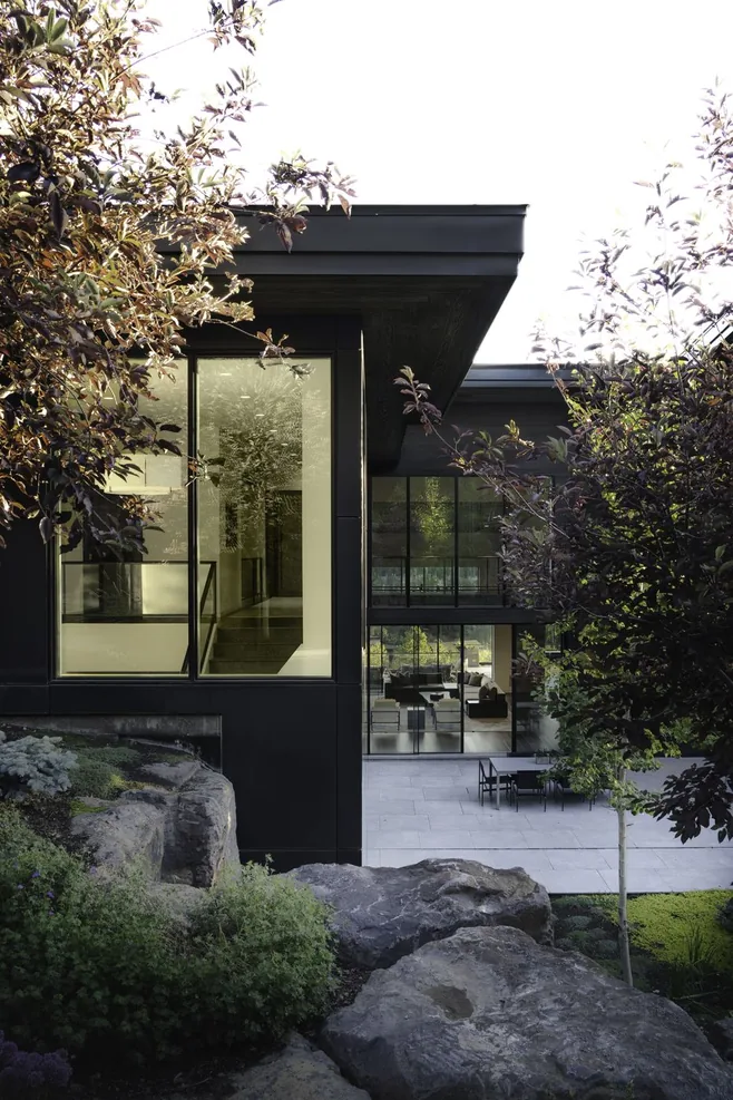 Lava rock garden and planting between the glass wing and the hillside