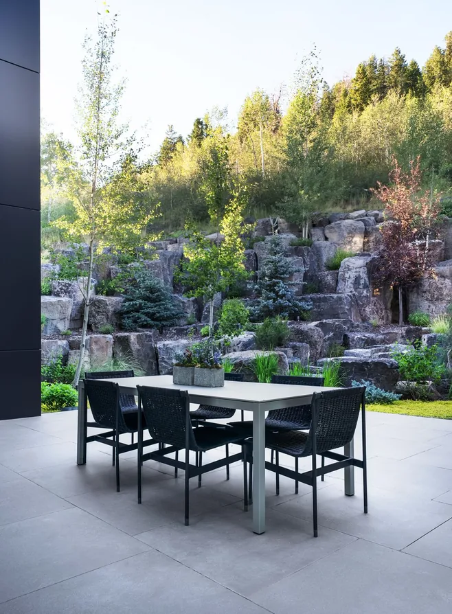 Outdoor dining table set against the lava rock garden and aspens