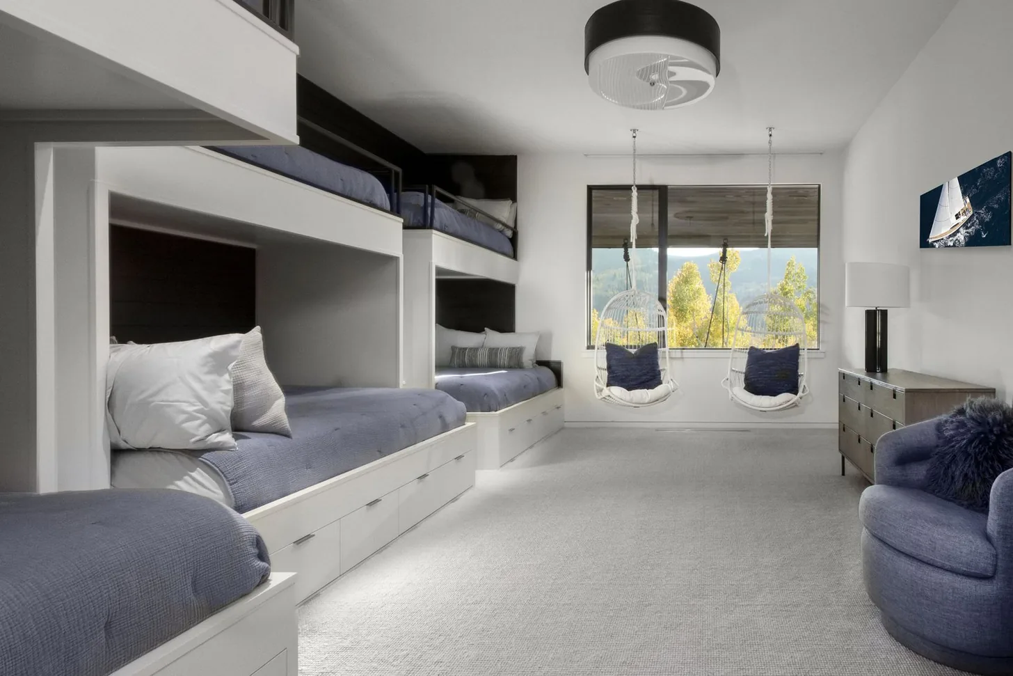 Second bunk room with built-in beds, hanging chairs and a window onto the aspens