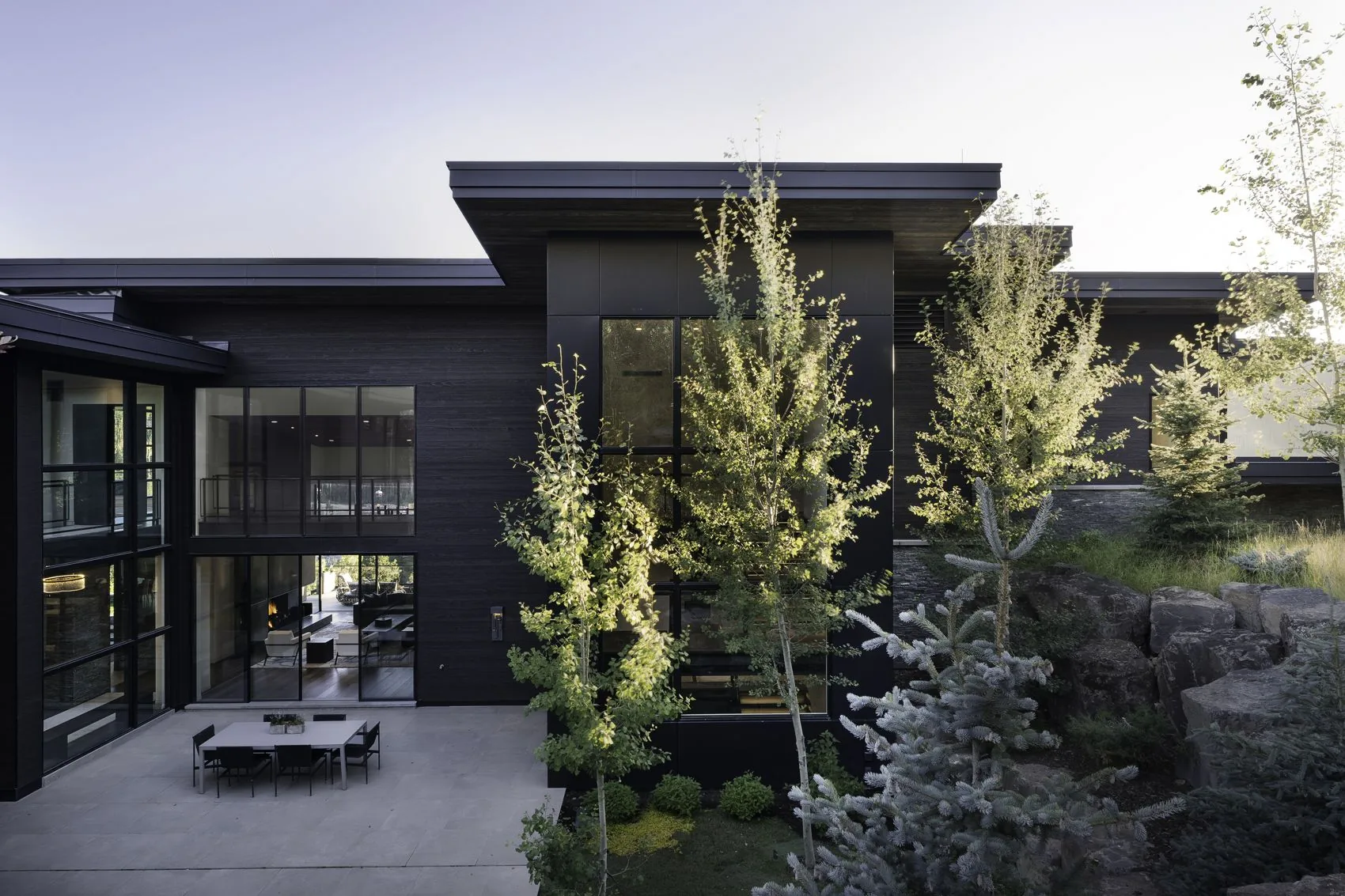 Terrace and planted garden against the dark facade at dusk
