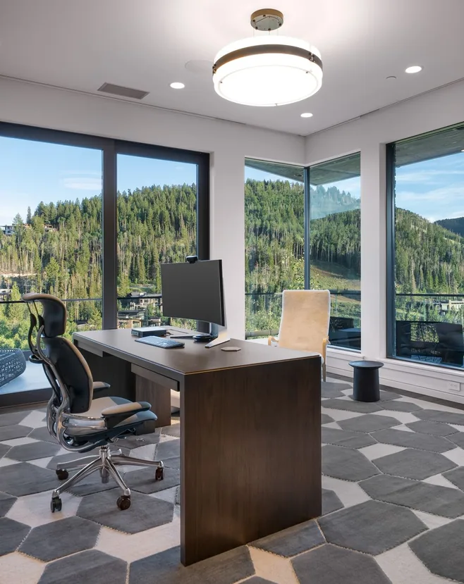 Upstairs glass-walled office with desk and views across The Colony