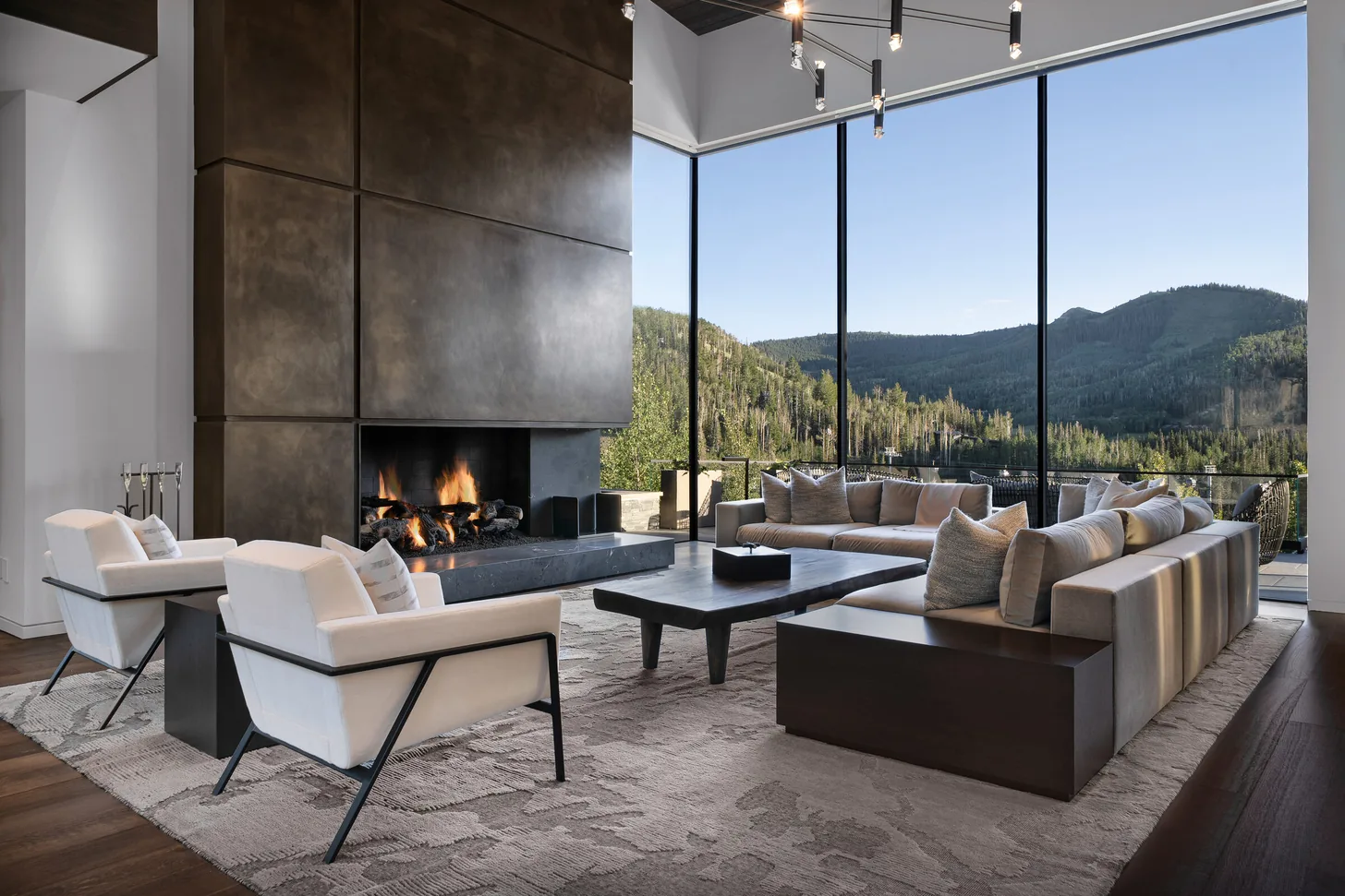 Great room with fireplace and floor-to-ceiling mountain views