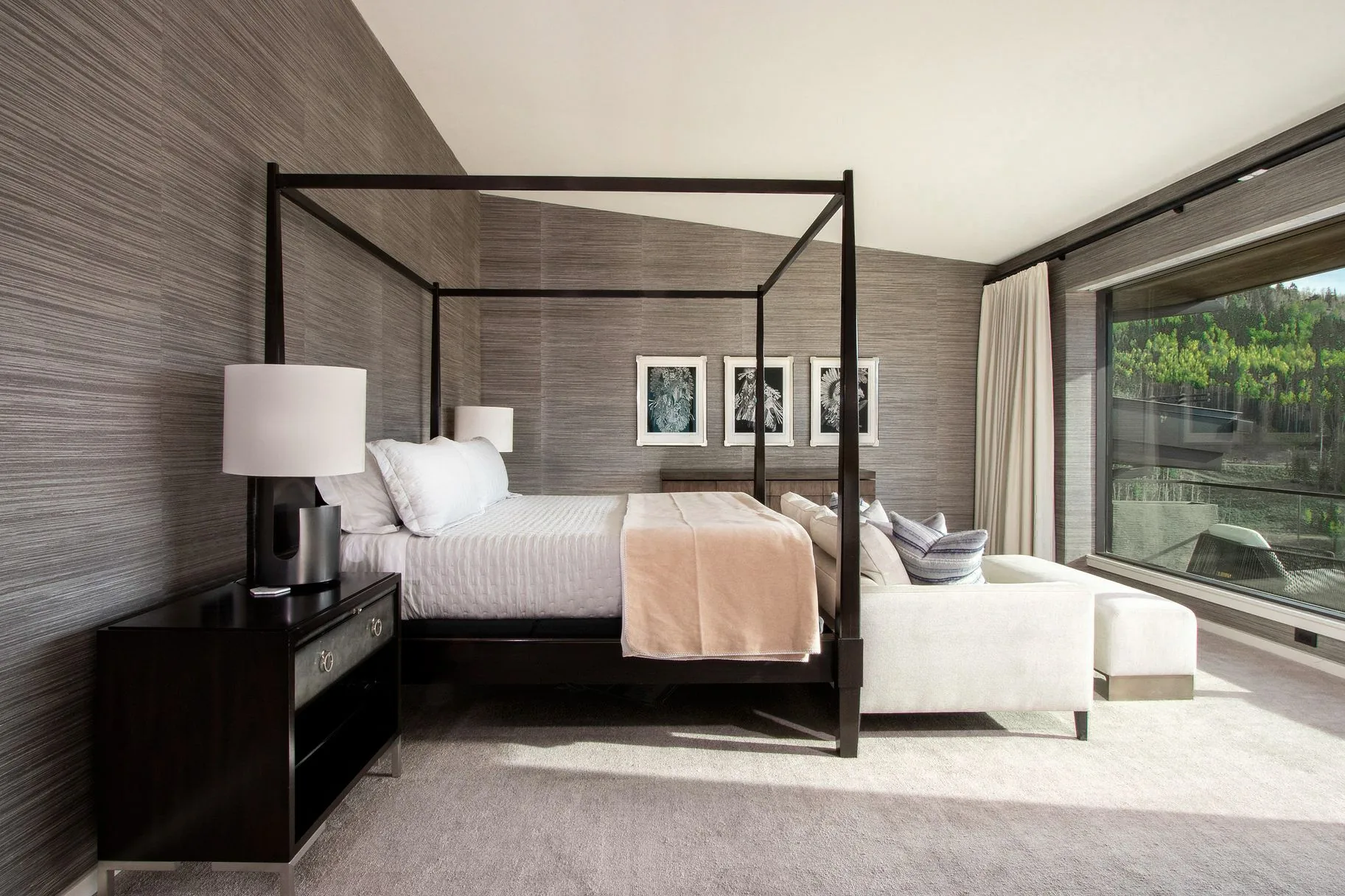 Primary bedroom with four-poster bed, textured wall covering and a picture window onto the aspens