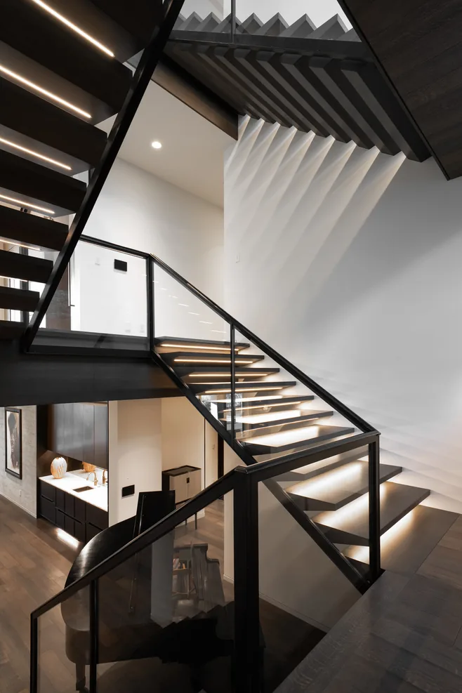 Floating staircase with backlit treads between levels